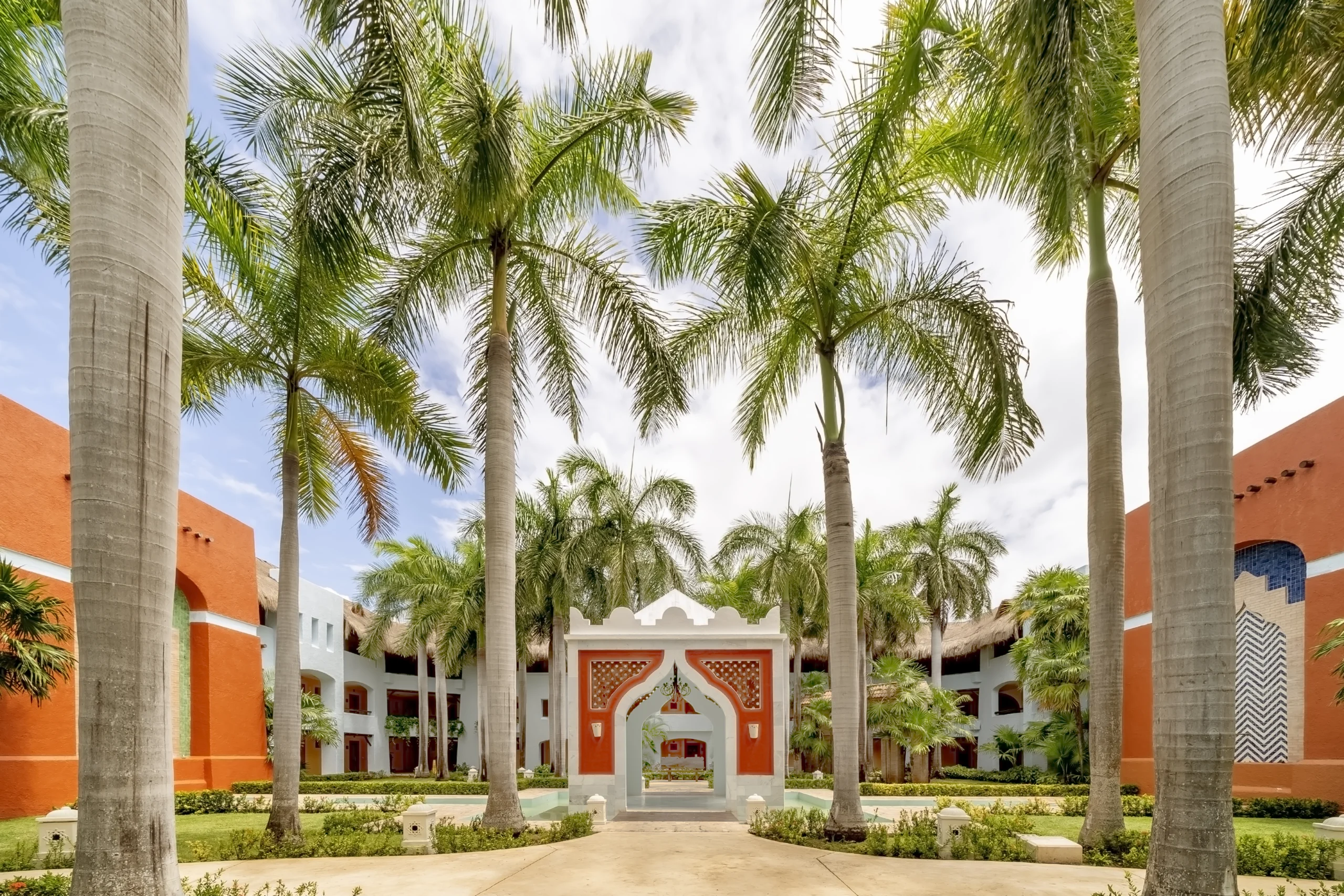 Patio central de estilo colonial con altas palmeras en el hotel Iberostar Selection Paraíso Lindo.