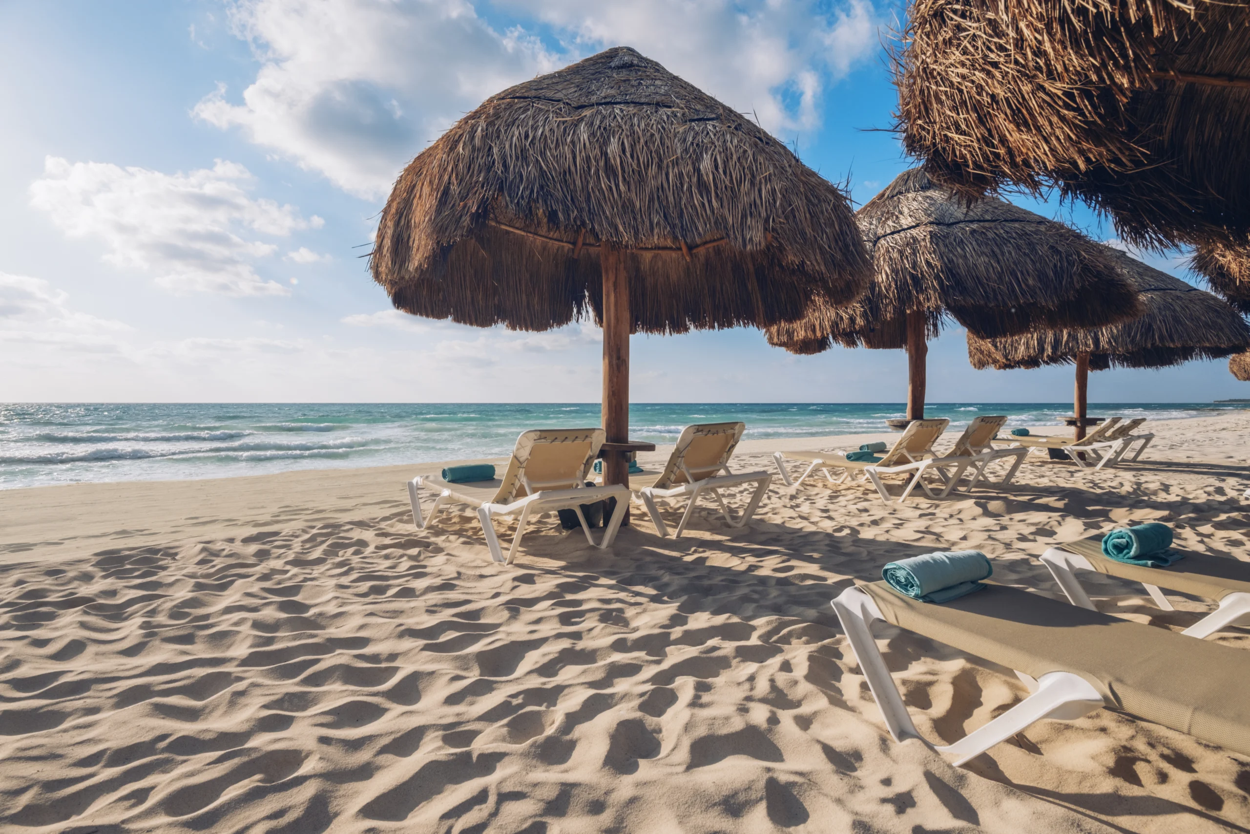 Playa privada con palapas y reposeras frente al mar en Iberostar Selection Paraíso Maya Suites.