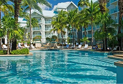 Fachada moderna y balcones con vista al mar de Kimpton Seafire Resort & Spa, rodeado de vegetación tropical