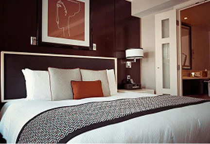 Habitación de lujo en Palm Heights con cama king size, diseño interior elegante en tonos chocolate y blancos, y vista al baño privado.