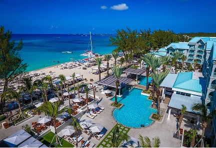 Vista aérea de las extensas piscinas frente al mar y la zona de playa privada de The Westin Grand Cayman Seven Mile Beach Resort & Spa.